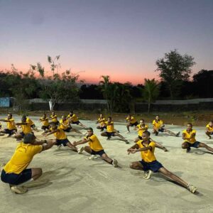 Group os students stretching at sunset outdoors.
